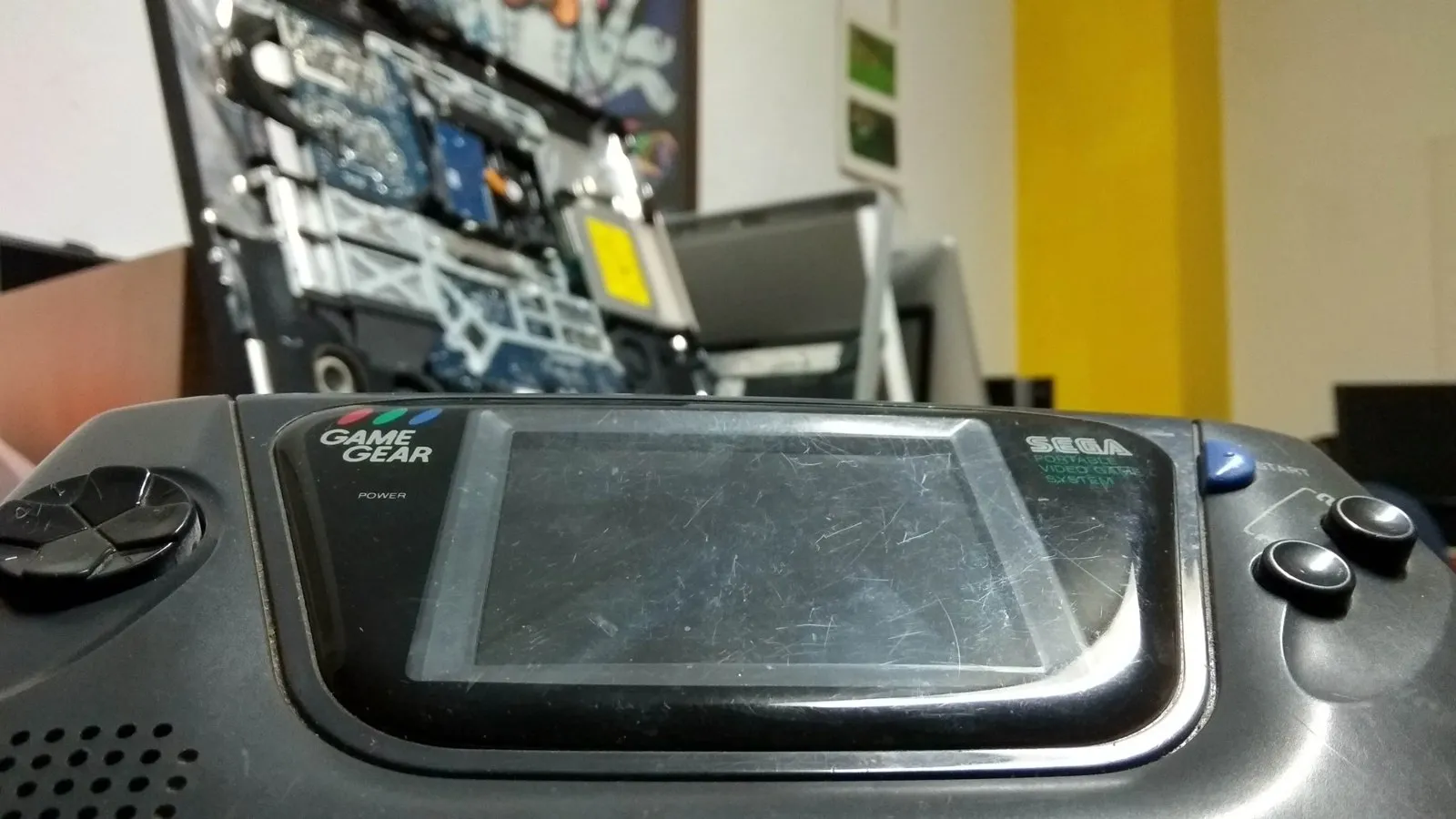 Banco de trabajo del taller de GadesPC con un portátil abierto y una consola en reparación